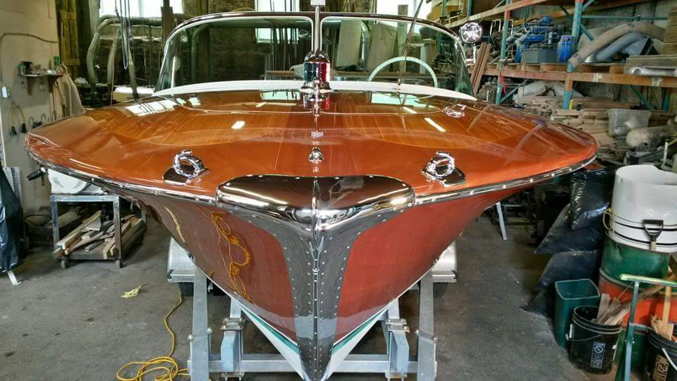 front of restored boat in workshop